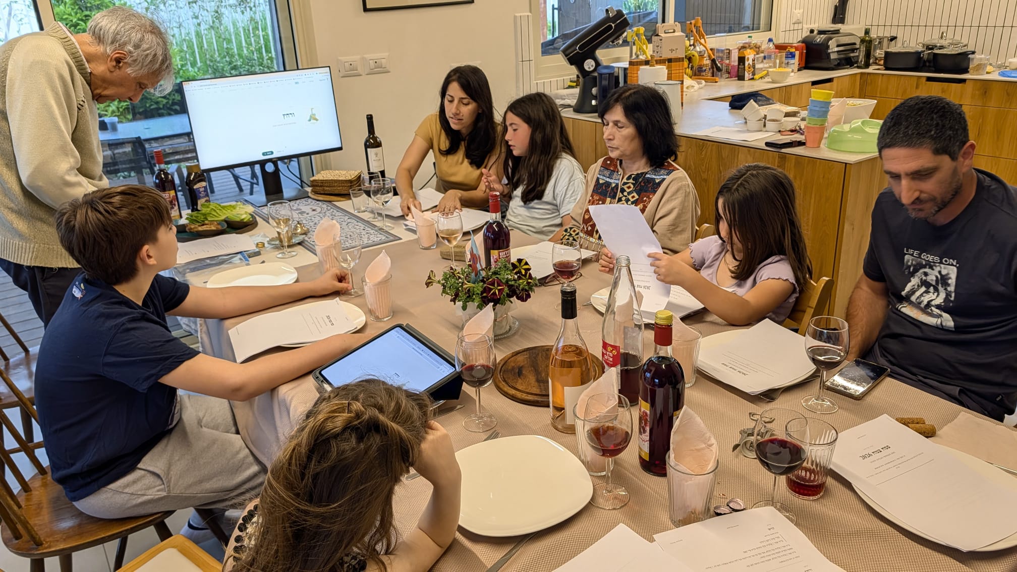 Family gathered around the Seder table using the digital Haggadah